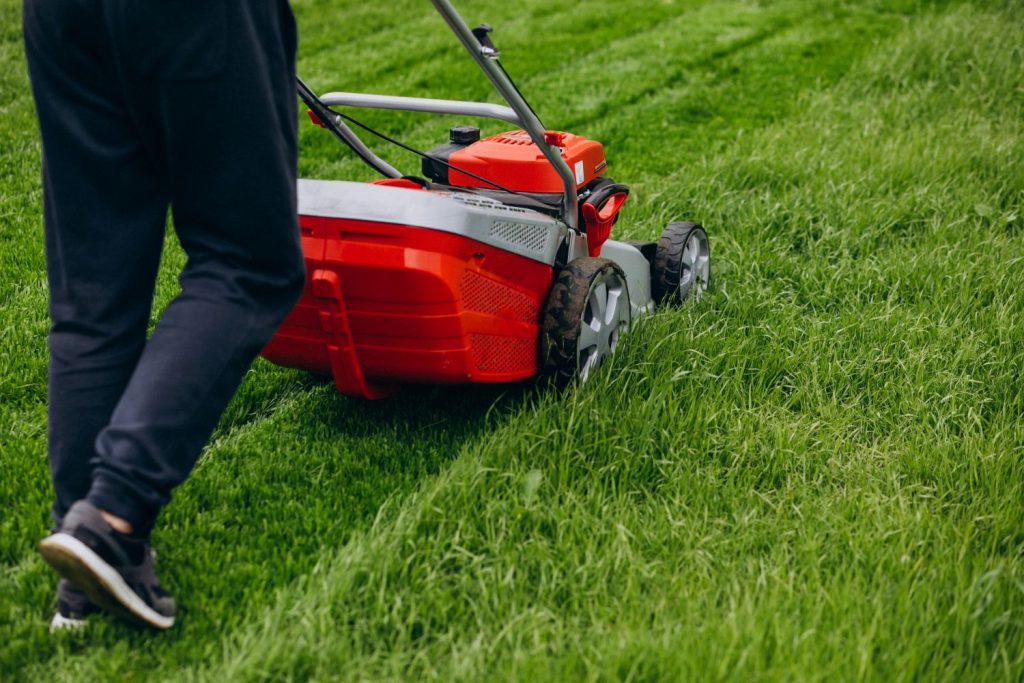Rasenmäher schneidet frisches grünes Gras im Garten